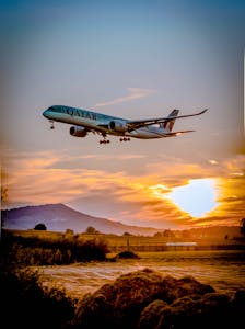 A passenger airplane flying over a scenic landscape at sunset, capturing the aviation spirit.